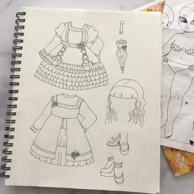 A sketchbook illustration of gothic fashions for paper dolls.
